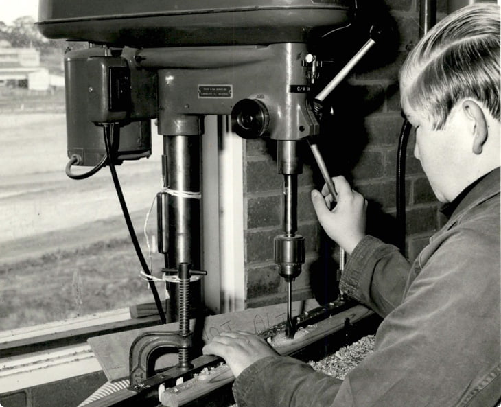 a black and white image of someone working on a plunge drill