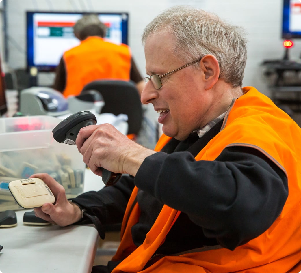 a smiling employee is scanning an e-tag