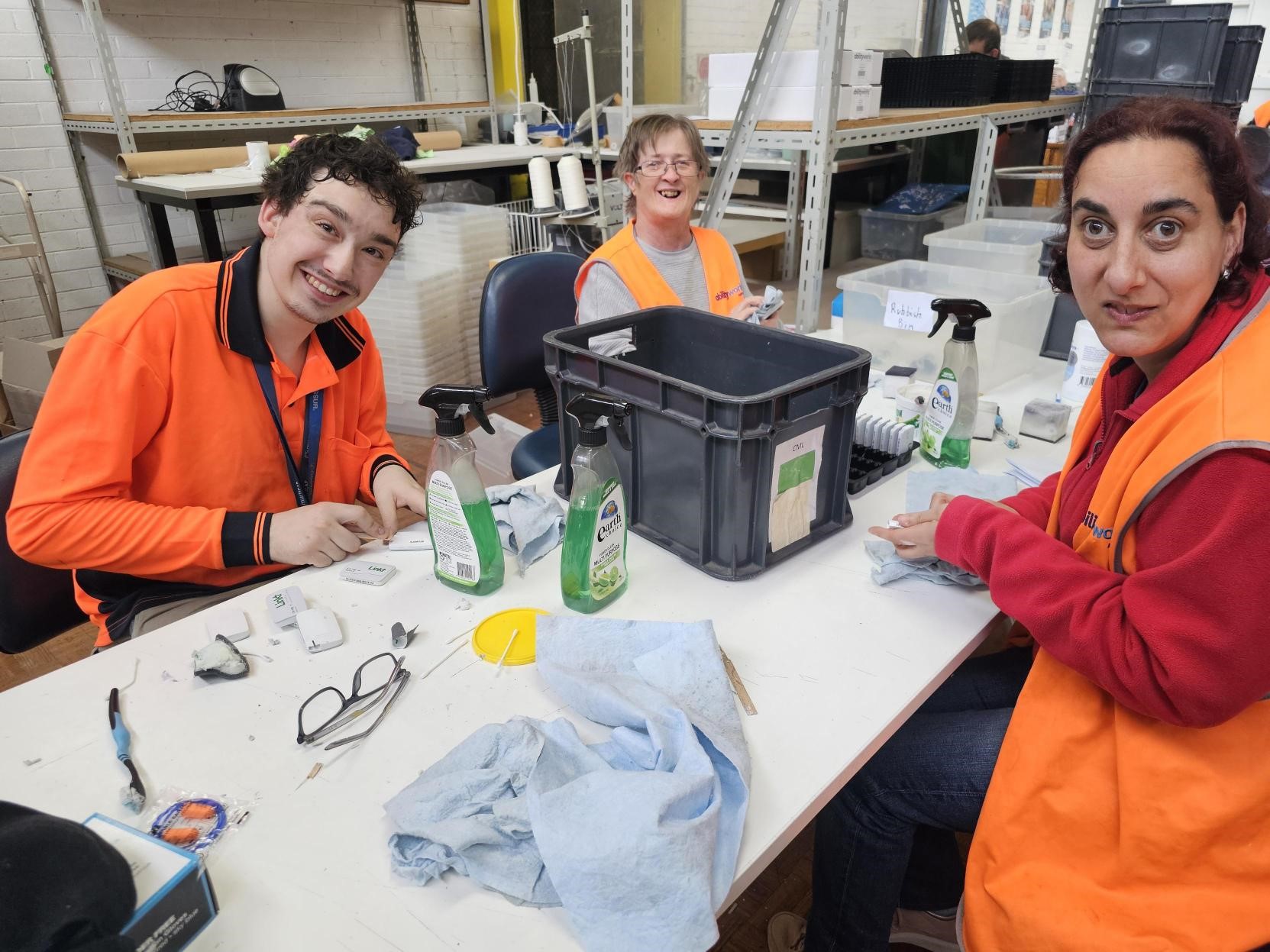 3 smiling employees cleaning e-tags for Transurban
