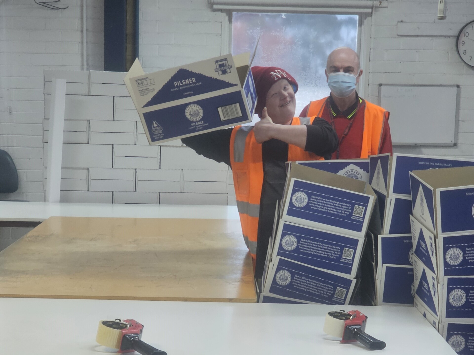 A cheeky Michael showing his well-folded Pilsner box with a thumbs up. Michael can be seen behind him.