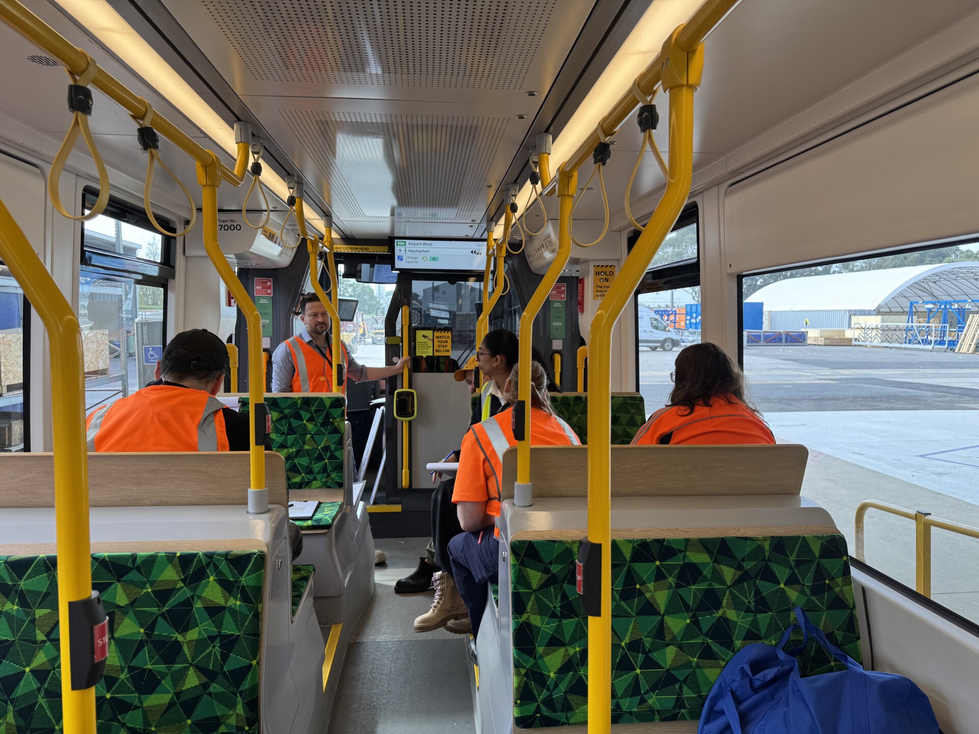Interior view of a Next Generation Tram mock-up. People are sitting and standing in the tram, engaged in discussion.