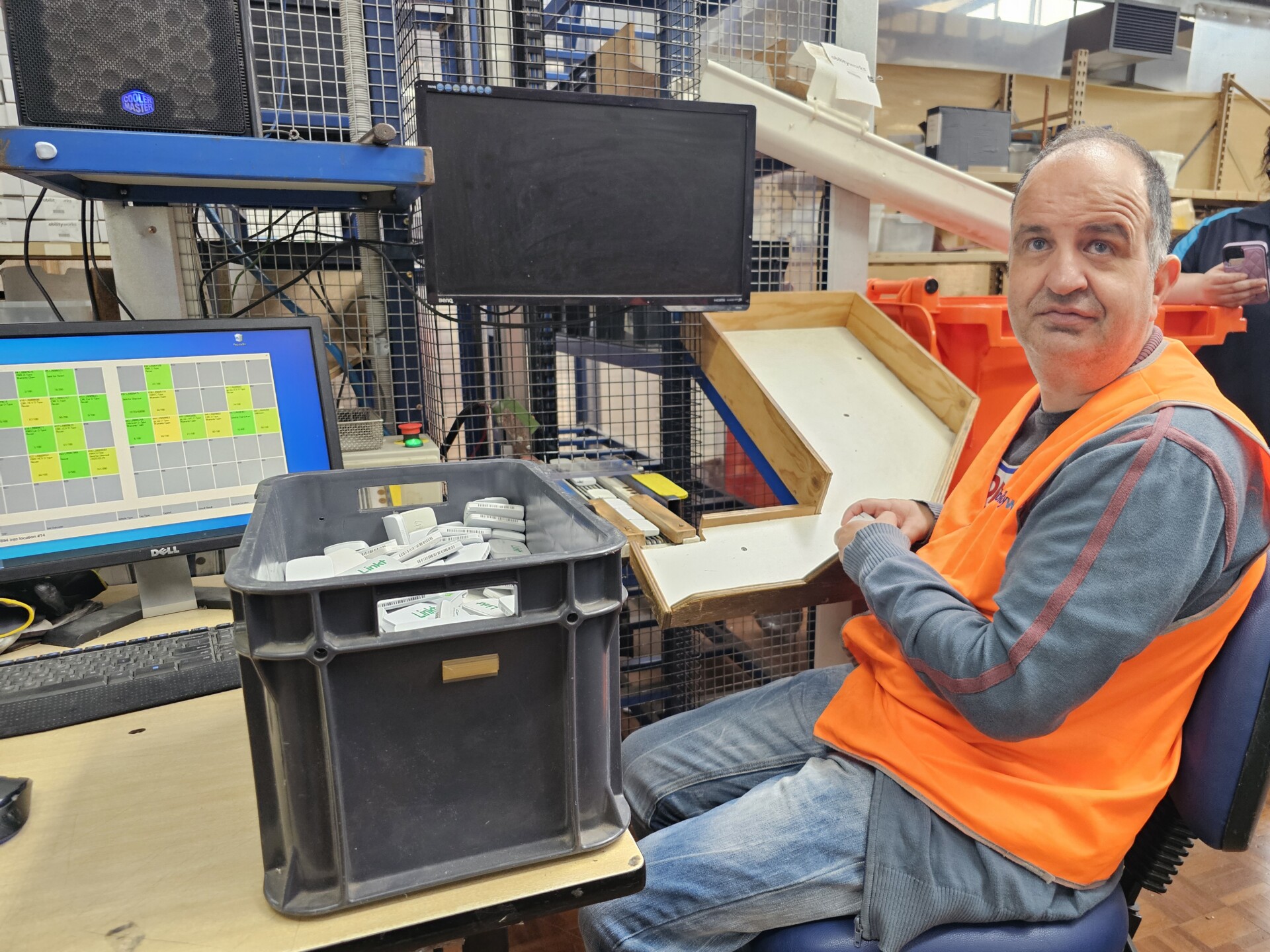 George poses for a picture in the mail room while he works on the sorting robot.