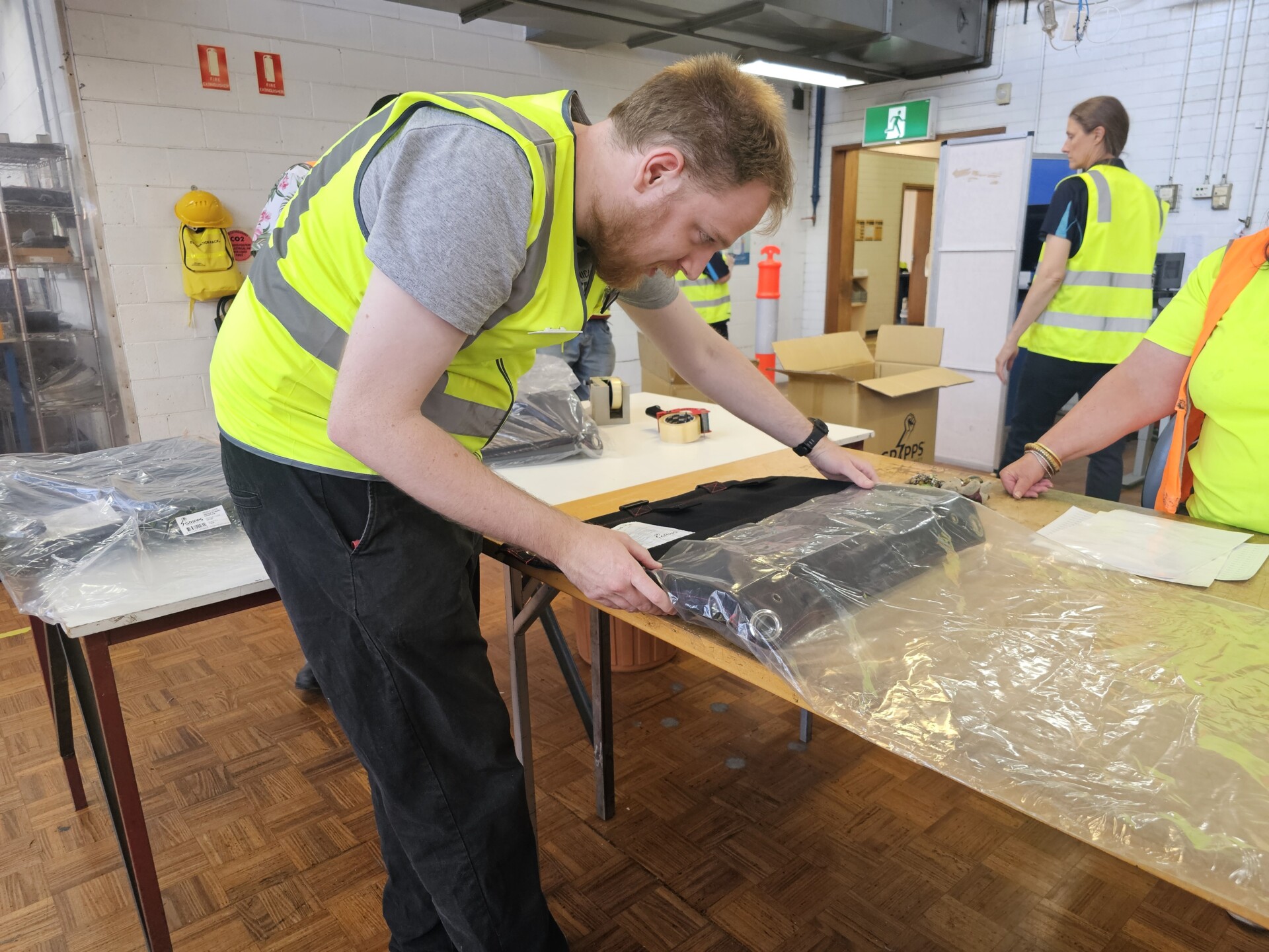 Edward is backing items into plastic sleeves